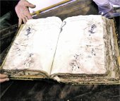 Uno de los tomos da&ntilde;ados por el agua mostrado ayer por los trabajadores del centro.