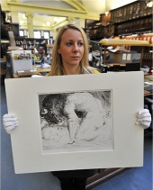 Uno de los gabados de la colecci&oacute;n mostrado por una empleada del museo